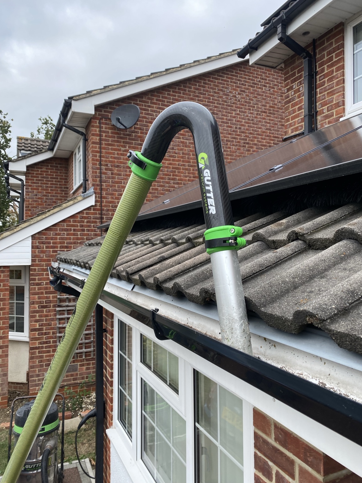 Professional gutter vacuum clearing a residential gutter
